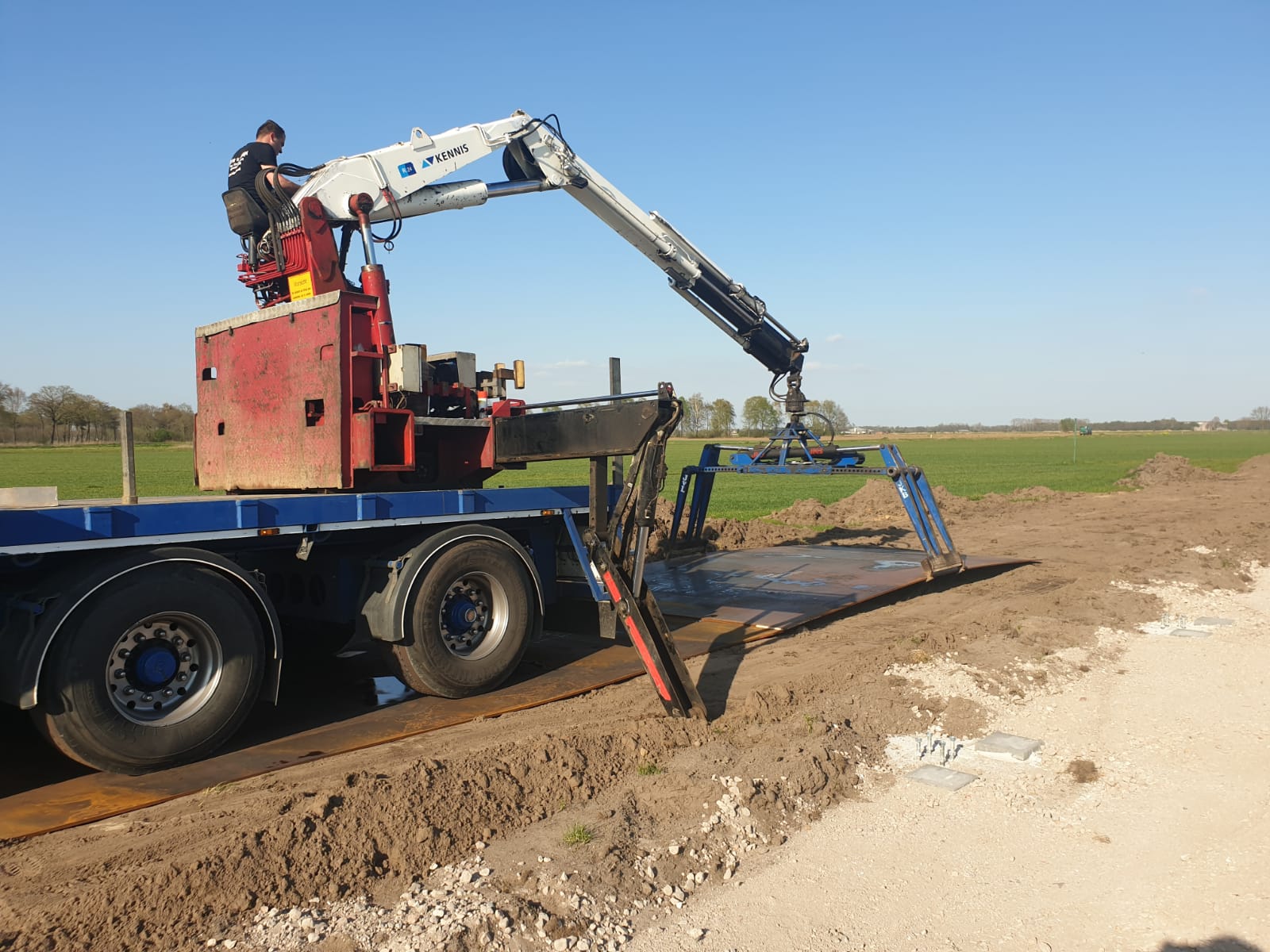 Extra brede rijplaten worden uitgelegd door kraanwagen