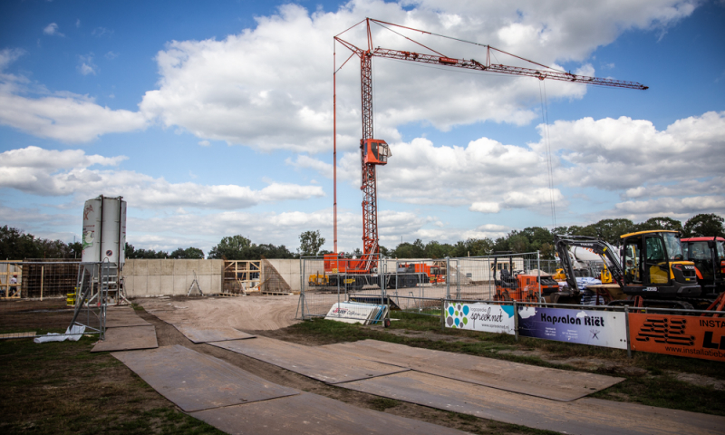 Rijplaten op bouwplaats met kraan en hekken