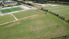 Dronefoto's van rijplaten leggen in een weiland naast een voetbalveld