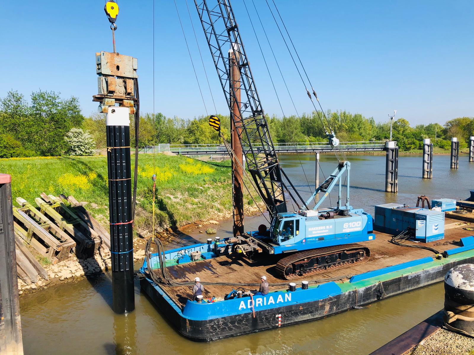 Meerpaal via kraan op boot in zetten